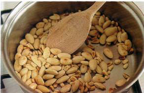 1	Обжарьте миндаль и орешки пинии на сухой сковороде на среднем огне до момента, когда они начнут слегка золотиться. 