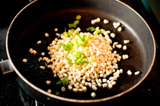 нагрейте сковороду на оливковом масле и обжарьте нарезанный лук-шалот и размороженную кукурузу