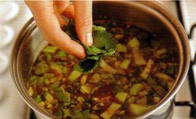 Нарежьте листочки кинзы, большую часть бросьте в суп вместе с нарезанны&not;ми белыми частями зеленого лука или порея. 